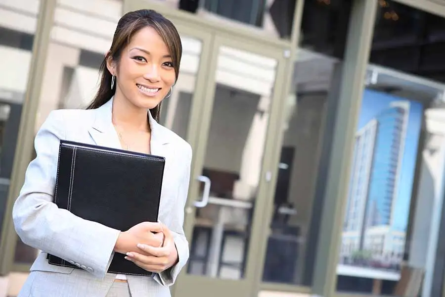 friendly singapore pr consultant standing in front of office building
